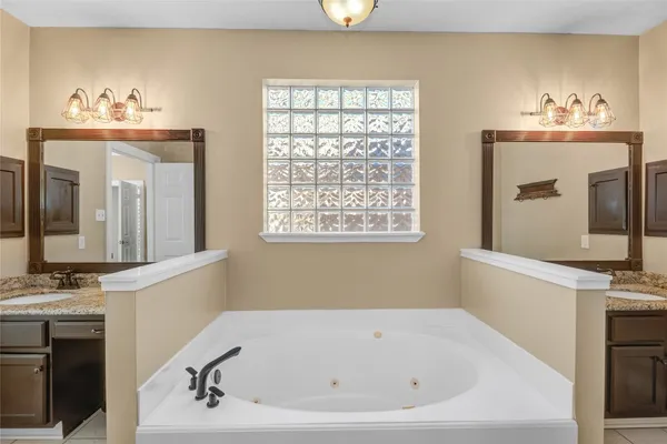 a bathroom with a bathtub sink and mirror