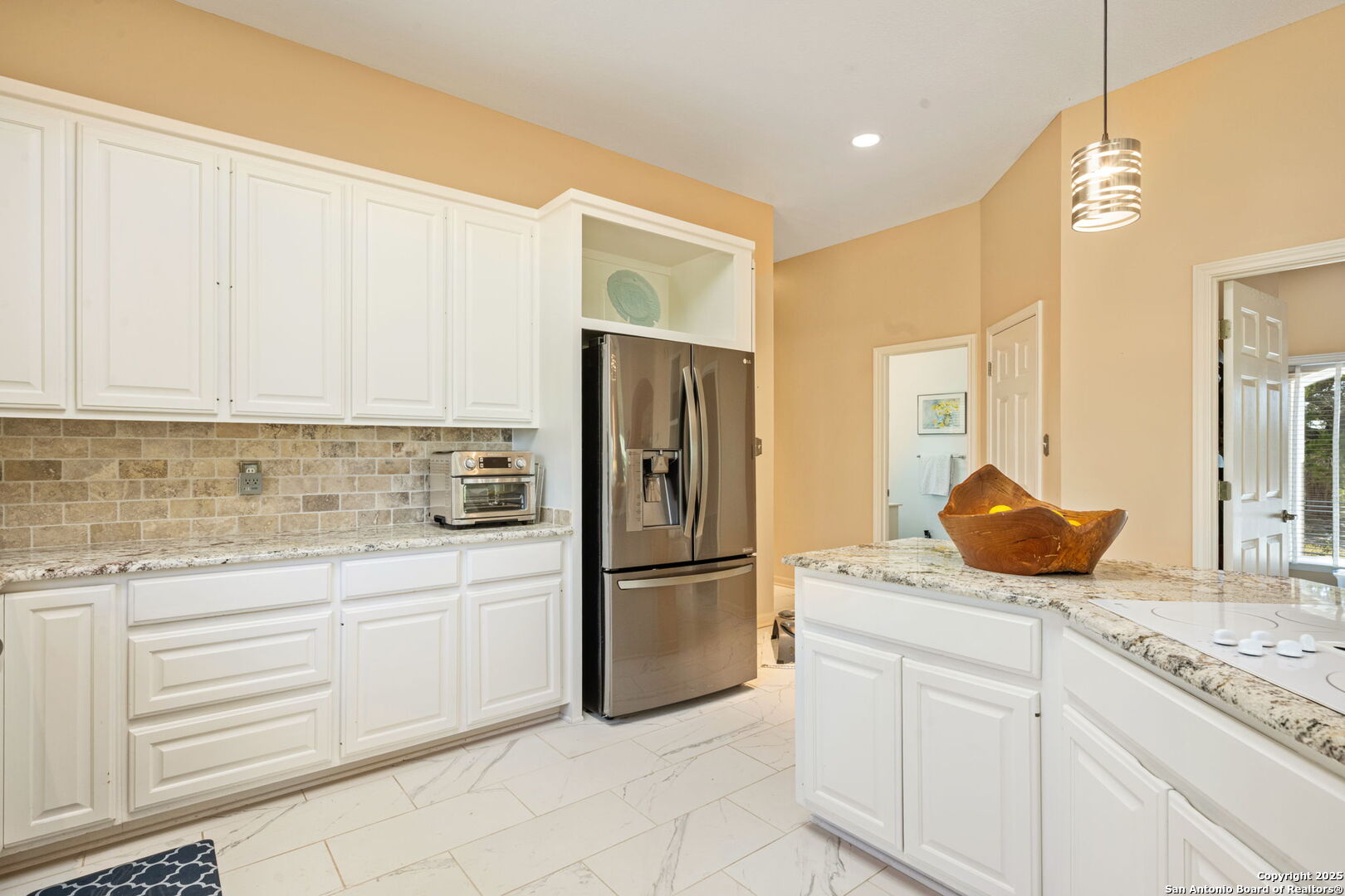 305 Spanish Pass Road Boerne, TX 78006 - Photo 95 of 105 a kitchen with granite countertop a refrigerator and white cabinets