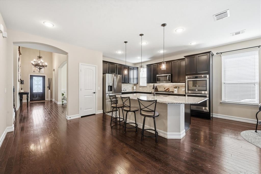 824 Pinnacle Ridge Road Fort Worth, TX 76052 - Photo 12 of 40 a kitchen with stainless steel appliances a dining table chairs and wooden floor