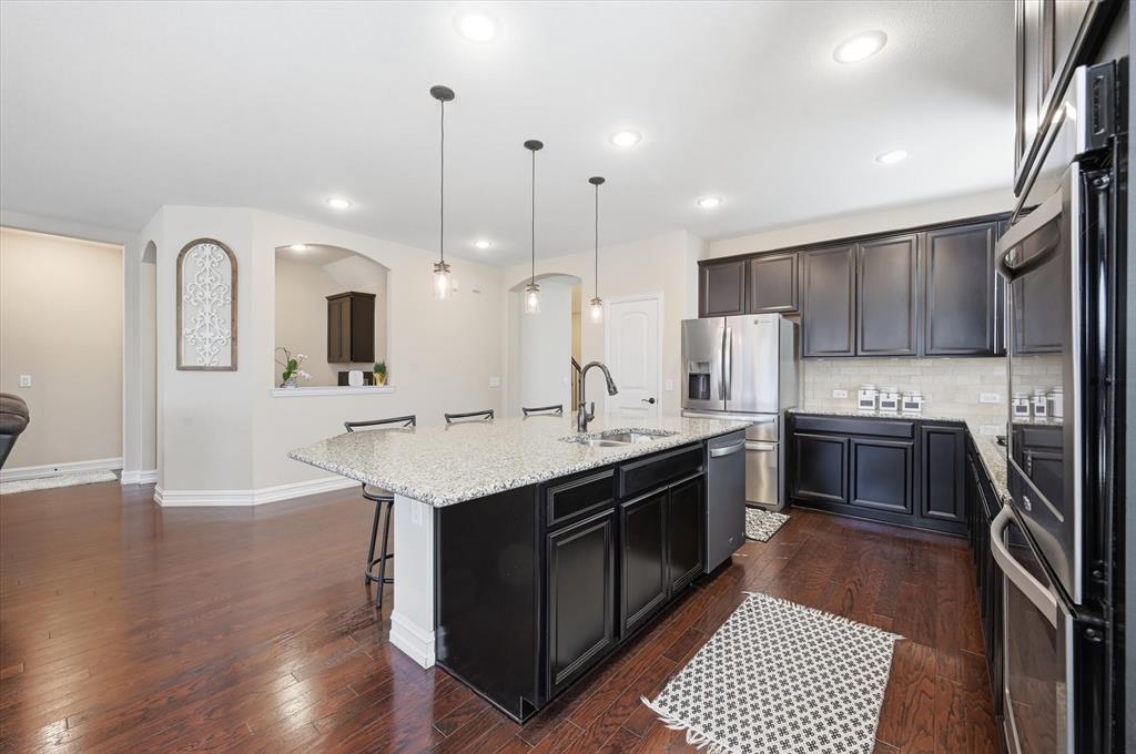 824 Pinnacle Ridge Road Fort Worth, TX 76052 - Photo 16 of 40 a kitchen with stainless steel appliances kitchen island a sink stove and cabinets