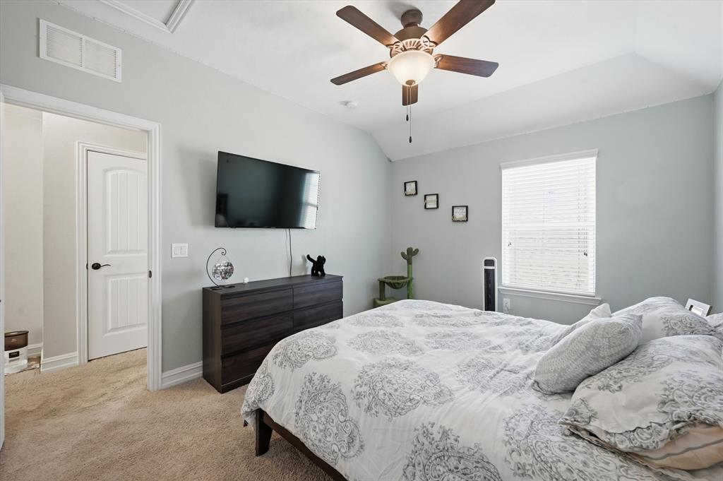 824 Pinnacle Ridge Road Fort Worth, TX 76052 - Photo 37 of 40 a spacious bedroom with a bed and a flat screen tv
