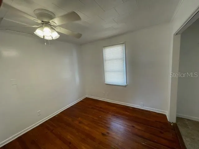 a view of wooden floor in an empty room with a window