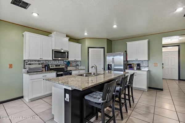 a kitchen with a dining table cabinets and appliances