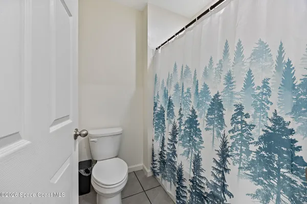 a white toilet sitting next to a shower curtain
