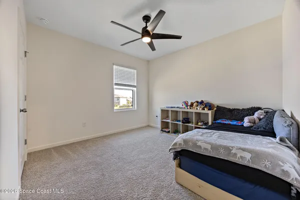 a bedroom with a bed and a ceiling fan