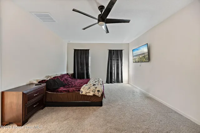 a bedroom with furniture and a ceiling fan