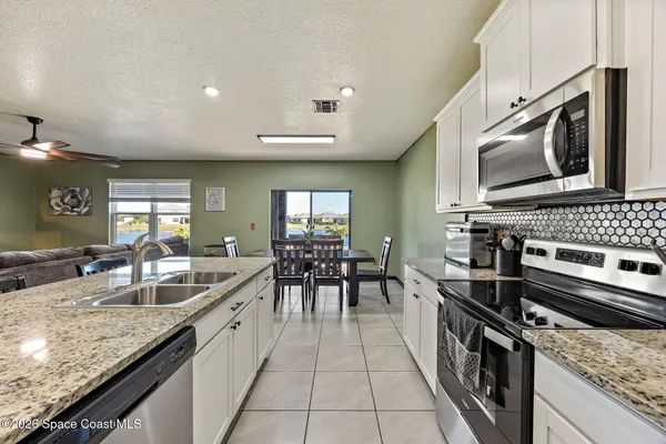 a large kitchen with granite countertop a stove and a sink