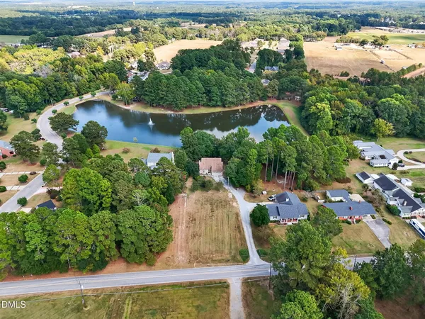 an aerial view of a house with a yard and lake view