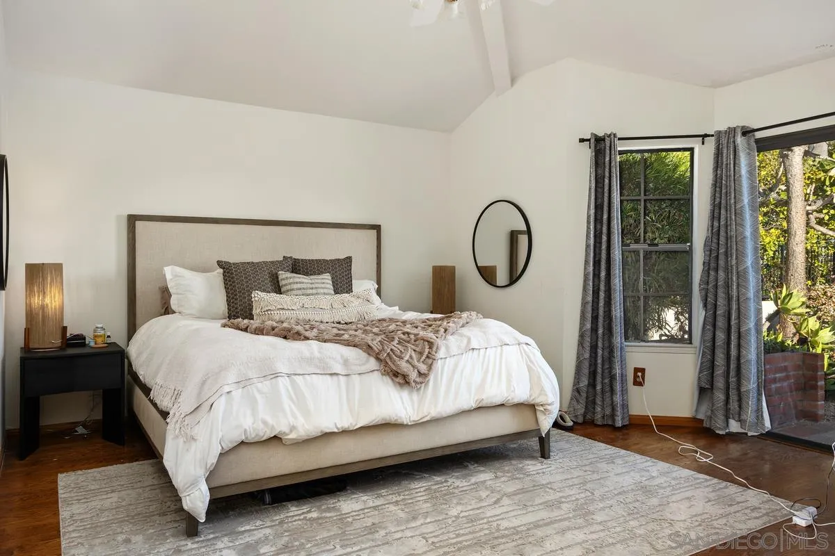 15089 Tierra Alta Del Mar, CA 92014 - Photo 13 of 25 a bedroom with a bed a mirror and a large window