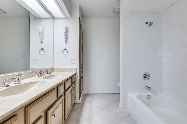 a bathroom with a granite countertop sink and a bathtub