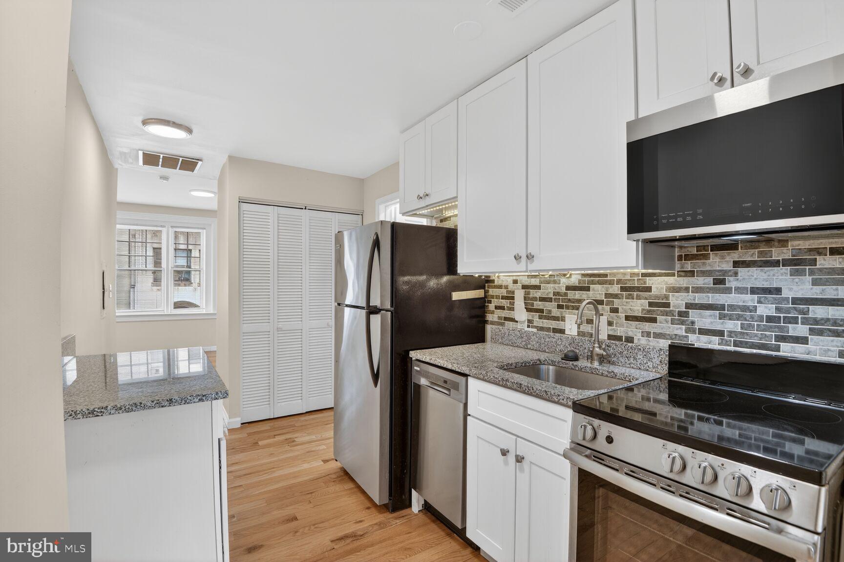 1648 Park Road Northwest, Unit 5 Washington, DC 20010 - Photo 1 of 15 a kitchen with stainless steel appliances a stove microwave and refrigerator