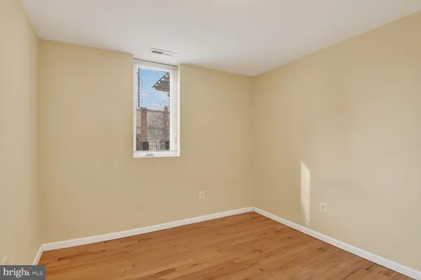 a view of an empty room with wooden floor