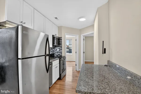 a metallic refrigerator freezer sitting in a kitchen