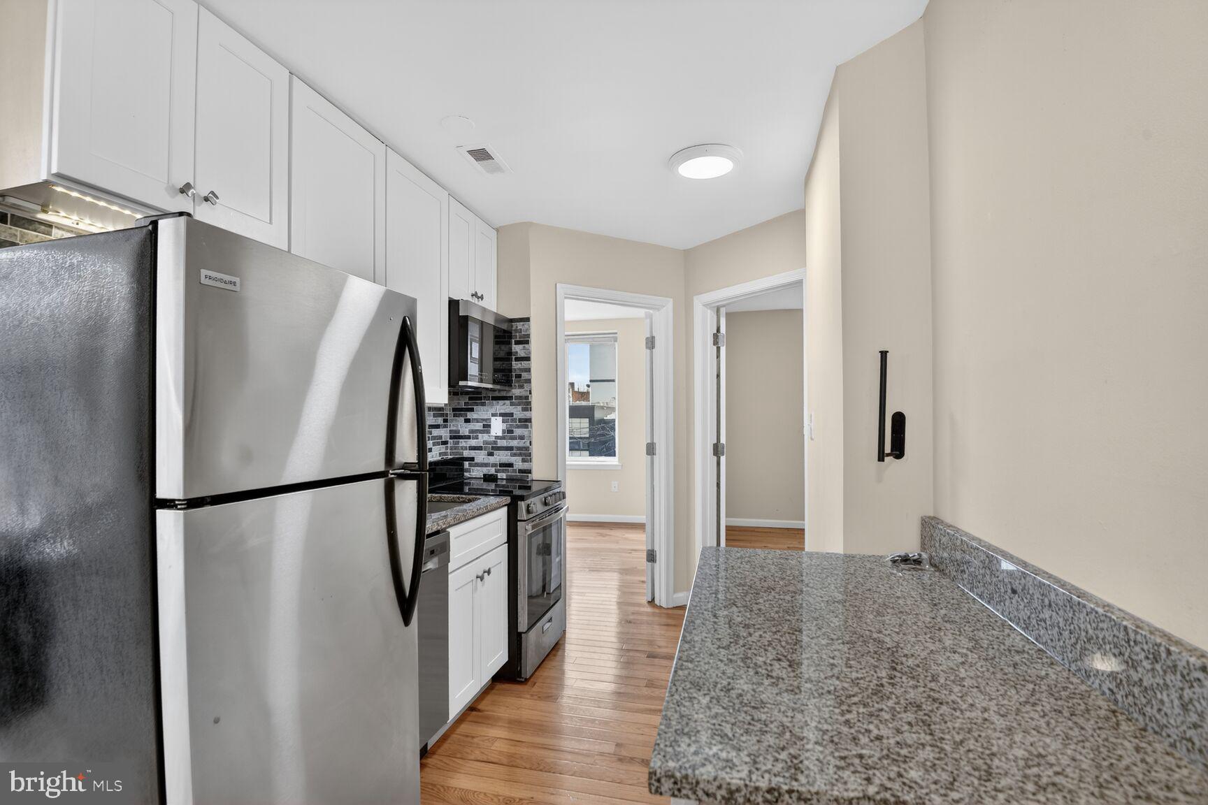 1648 Park Road Northwest, Unit 5 Washington, DC 20010 - Photo 5 of 15 a metallic refrigerator freezer sitting in a kitchen