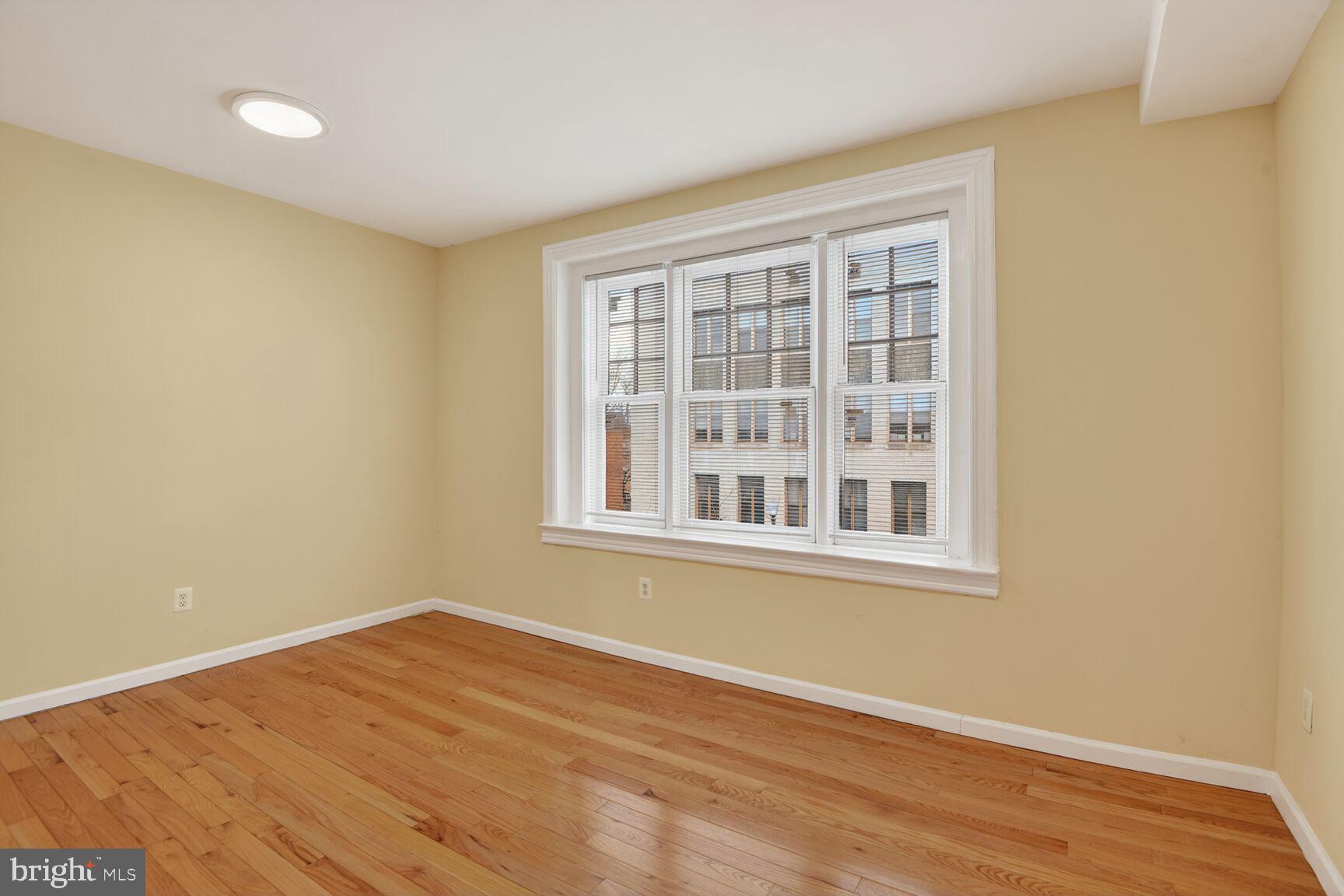 1648 Park Road Northwest, Unit 5 Washington, DC 20010 - Photo 7 of 15 a view of an empty room with wooden floor and a window