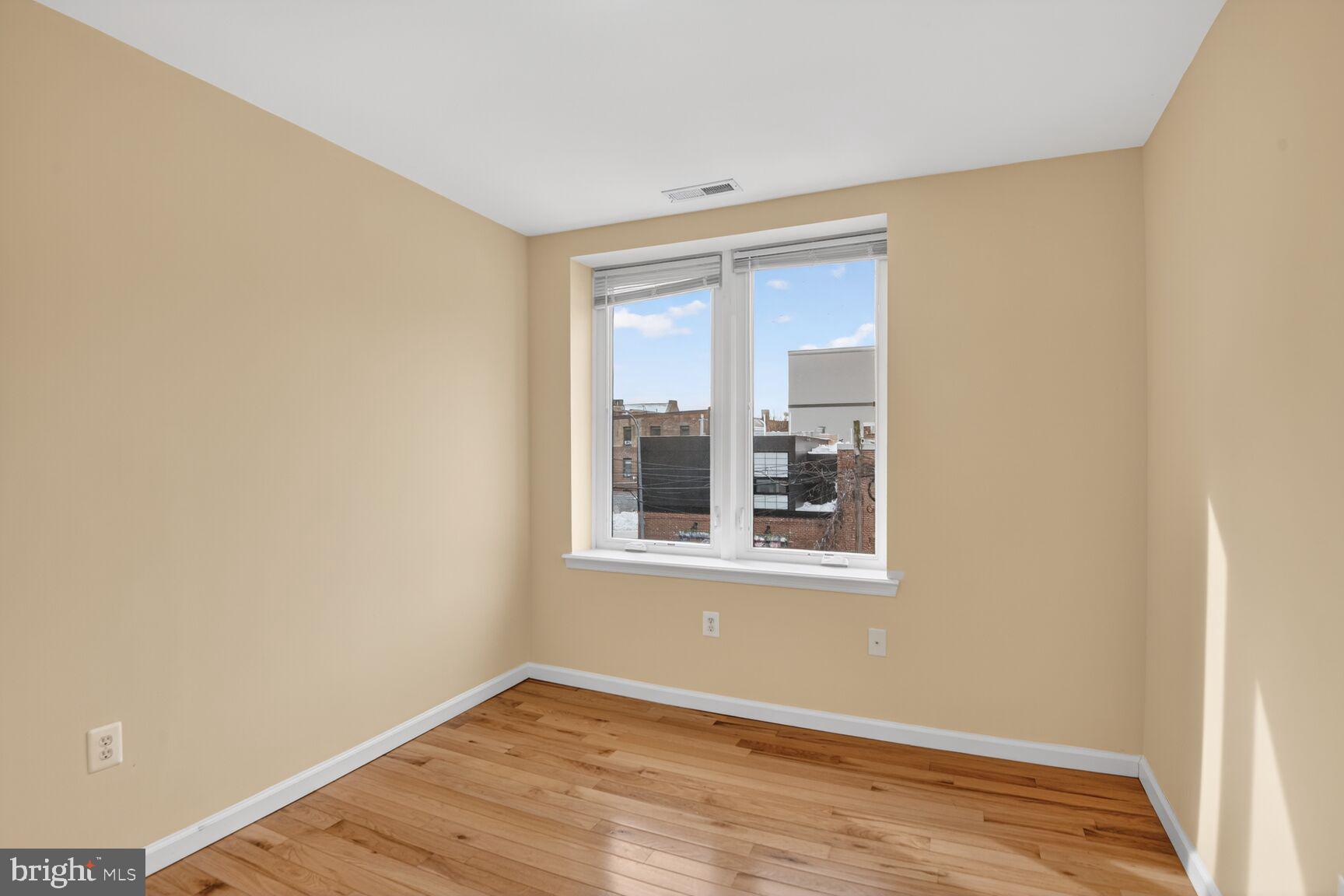 1648 Park Road Northwest, Unit 5 Washington, DC 20010 - Photo 9 of 15 a view of an empty room with wooden floor and a window