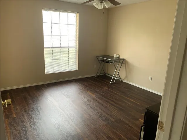 an empty room with a window and wooden floor