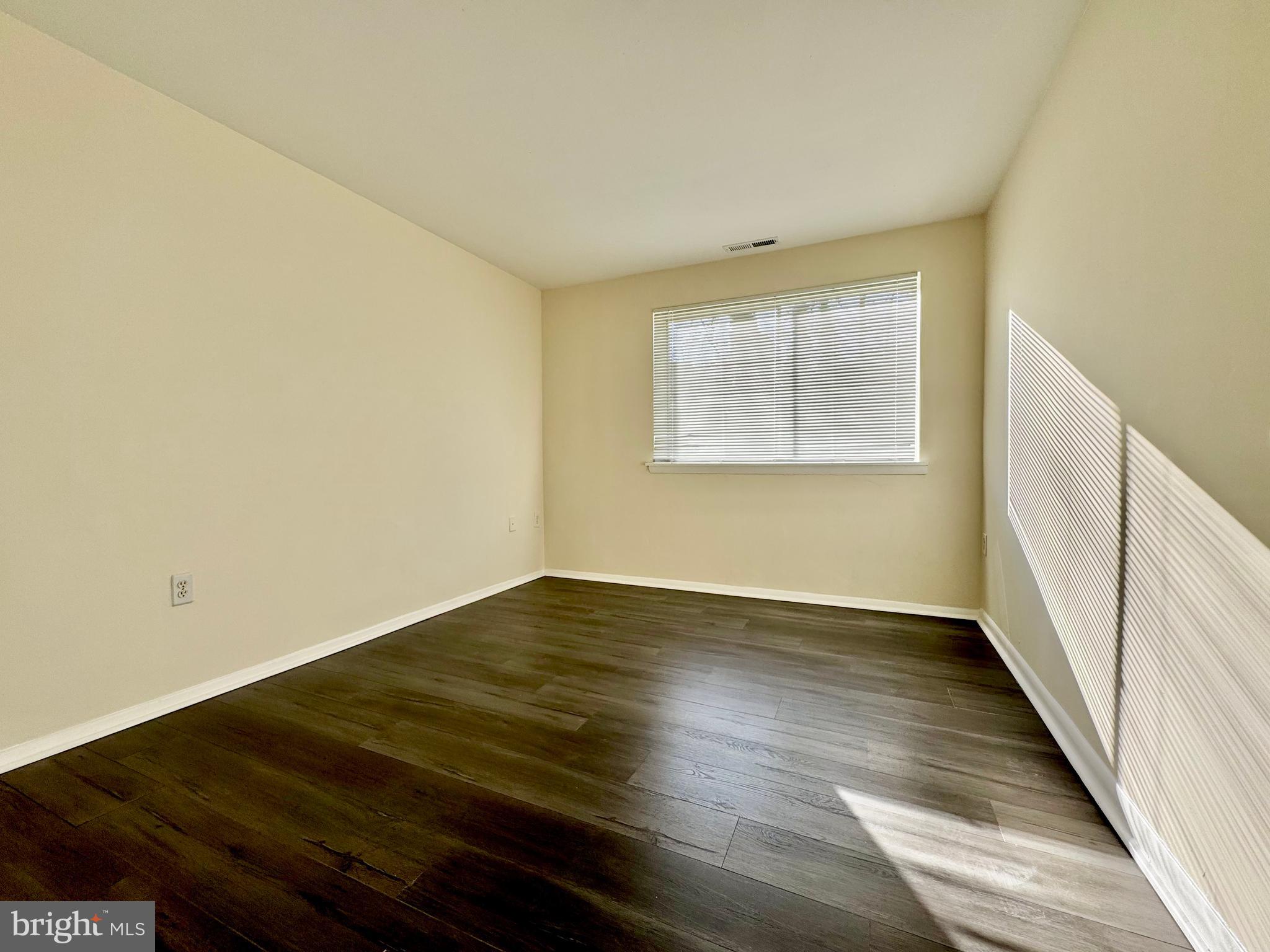 3936 Bel Pre Road, Unit 39362 Silver Spring, MD 20906 - Photo 22 of 32 an empty room with wooden floor and windows
