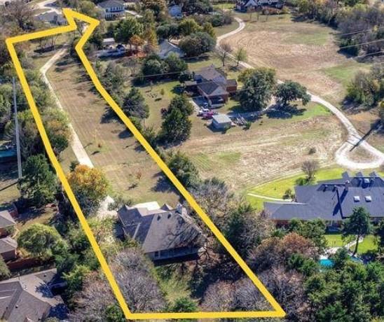 Expansive parcel featuring a long private driveway, mature trees, and a substantial residential structure