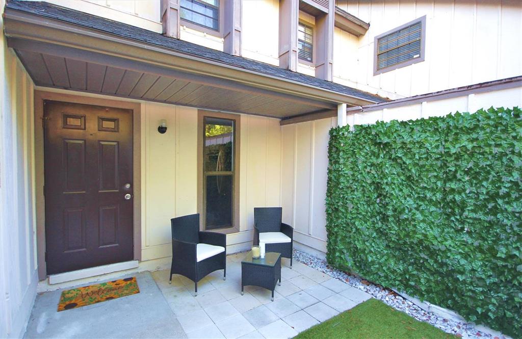 a view of backyard with outdoor seating and plants