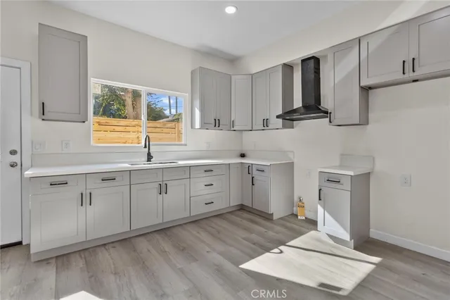 a kitchen with cabinets stainless steel appliances a sink and wooden floor
