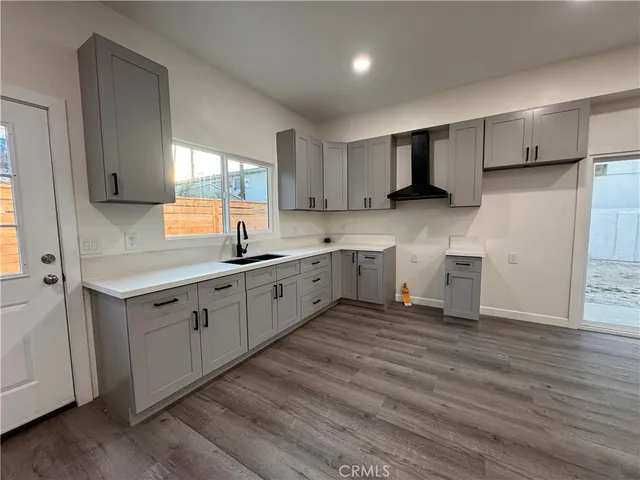 a kitchen with a sink cabinets and wooden floor