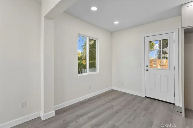an empty room with a window and wooden floor