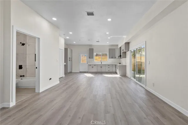 a view of a kitchen with wooden floor and a window