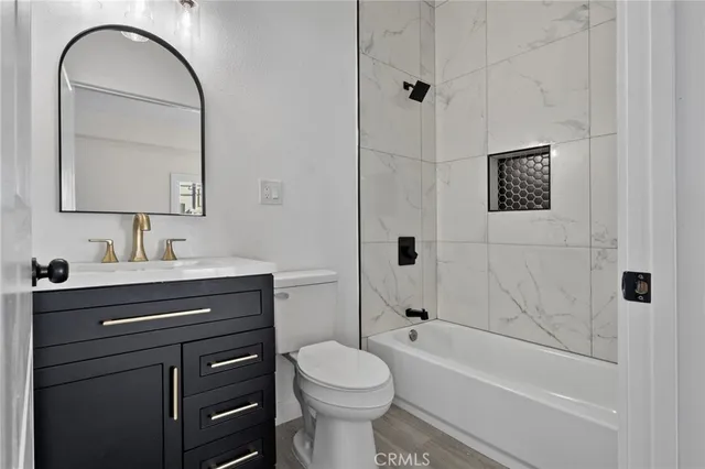 a bathroom with a toilet sink vanity tub and shower