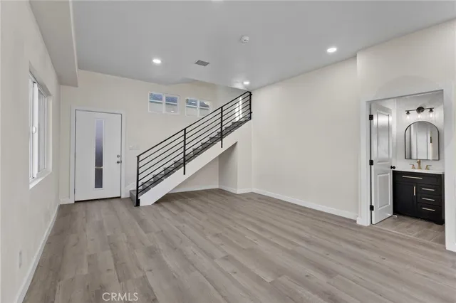 a view of a hallway with wooden floor and staircase