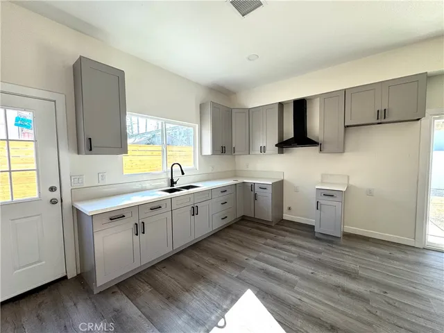 a kitchen with a sink cabinets and wooden floor