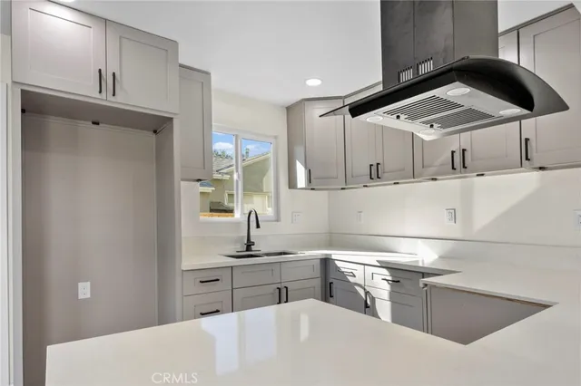a kitchen with stainless steel appliances kitchen island a sink a stove and white cabinets