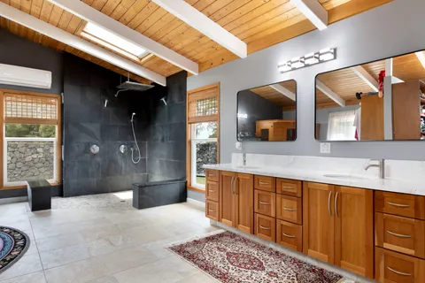 a bathroom with a sink a large mirror and a bathtub