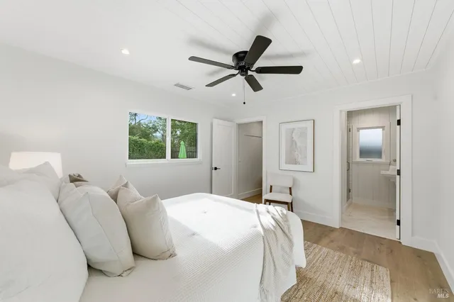 a bedroom with a bed and large windows