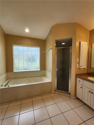 a spacious bathroom with a tub shower and sink