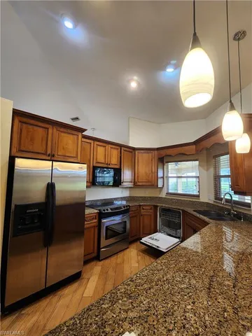a kitchen with stainless steel appliances granite countertop a refrigerator and stove