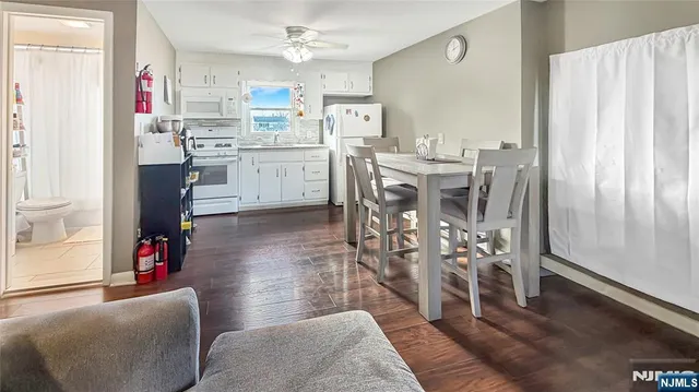 a living room with stainless steel appliances kitchen island granite countertop furniture and a dining table