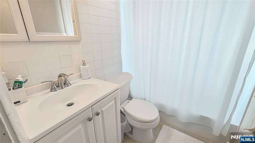 154 Charlton Avenue, Unit 2 Lodi, NJ 07644 - Photo 8 of 14 a bathroom with a sink a toilet and vanity