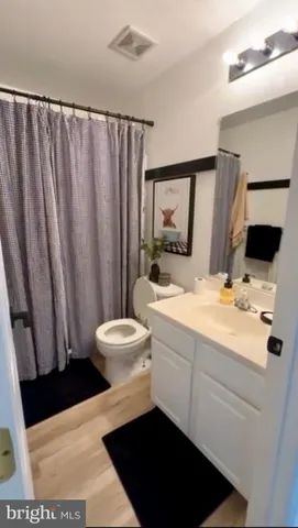 a bathroom with a sink a toilet a mirror and shower curtain