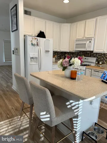 a kitchen with a sink chairs and cabinets