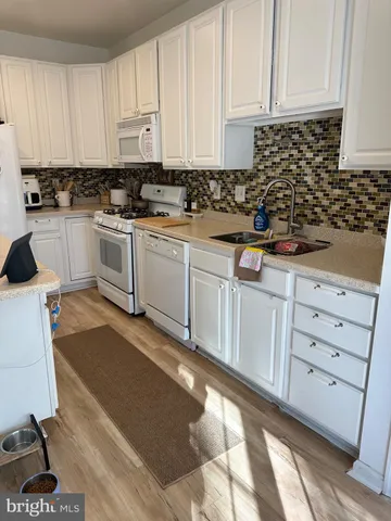 a kitchen with granite countertop a sink a stove and cabinets