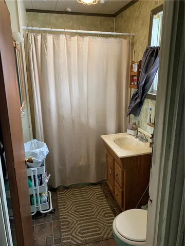 a bathroom with a sink a toilet a mirror and shower curtain