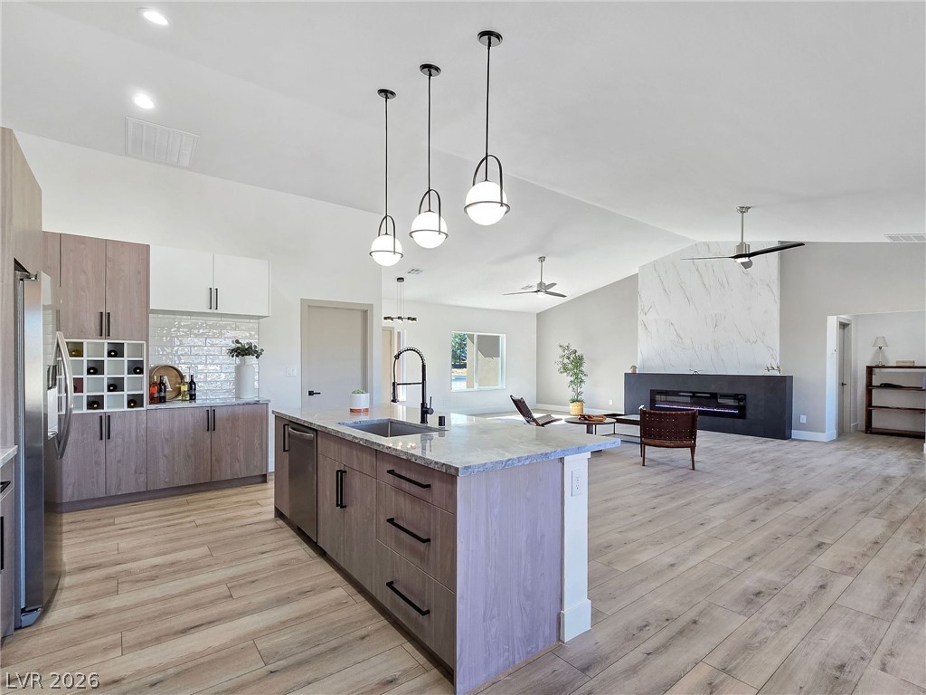 1120 West Gamebird Road Pahrump, NV 89048 - Photo 36 of 36 Kitchen featuring vaulted ceiling, open floor plan, hanging light fixtures, a ceiling fan, and light wood-type flooring