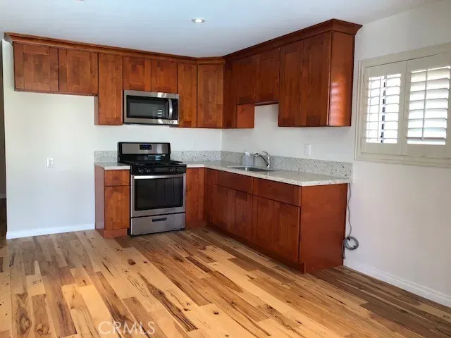 a kitchen with stainless steel appliances granite countertop a stove a sink and a microwave