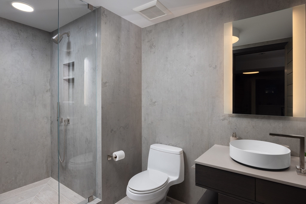 10 Spooner Road Brookline, MA 02467 - Photo 18 of 26 a bathroom with a granite countertop sink toilet a mirror and shower