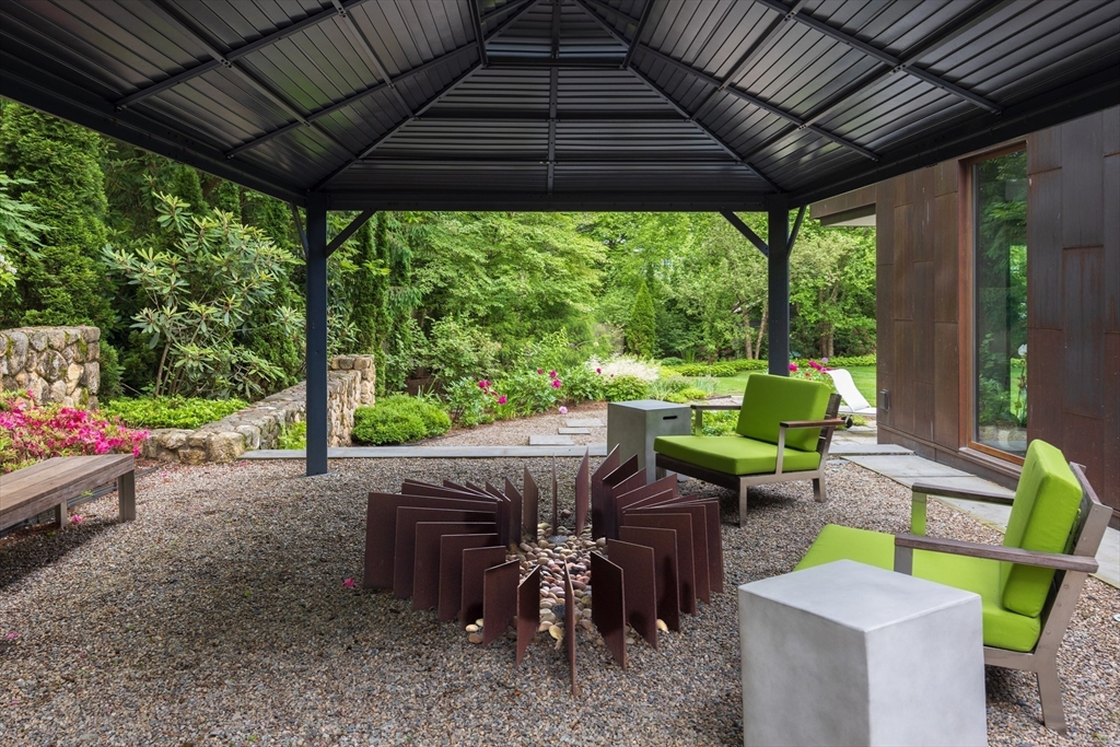10 Spooner Road Brookline, MA 02467 - Photo 22 of 26 a view of a patio with table and chairs under an umbrella with a yard