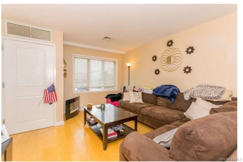 1490 Outlook Avenue, Unit 1A Bronx, NY 10465 - Photo 3 of 12 Living area with light wood-style flooring and baseboards