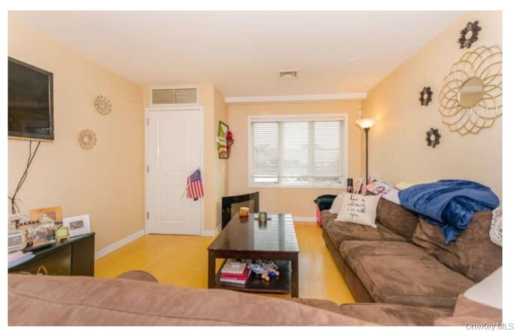 1490 Outlook Avenue, Unit 1A Bronx, NY 10465 - Photo 4 of 12 Living room featuring wood finished floors and baseboards