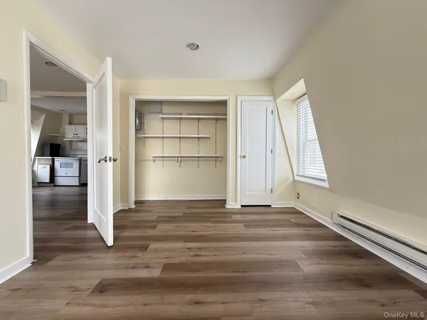 a view of empty room with wooden floor and window