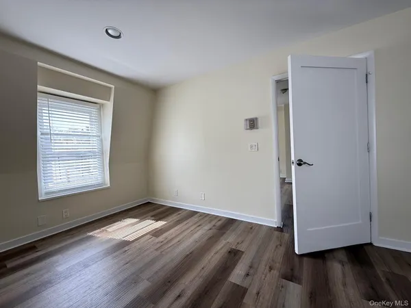 an empty room with wooden floor and a window